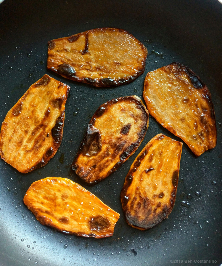 thinly sliced sweet potatoes grilled in a round skillet