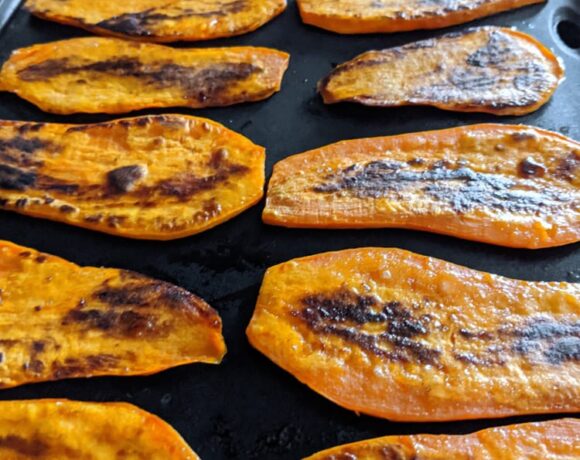 thinly sliced sweet potatoes grilled on a large flat electric skillet
