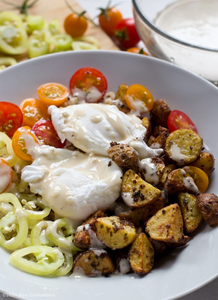 air fryer potatoes in a bowl with poached eggs and vegetables