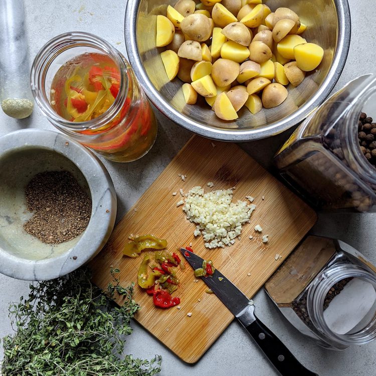 ingredients for jerk seasoned potatoes, thyme, black pepper, allspice, Scotch Bonnet peppers, potatoes, and garlic