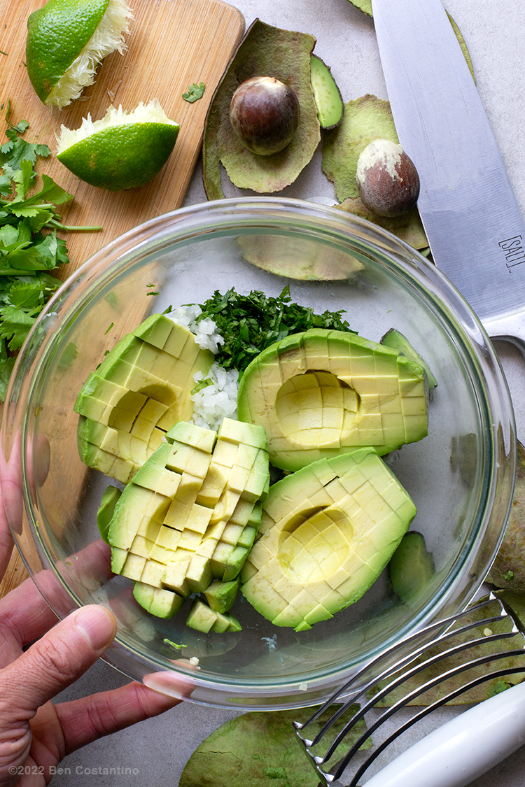 cubed avocado in a bowl with other guacamole ingredients