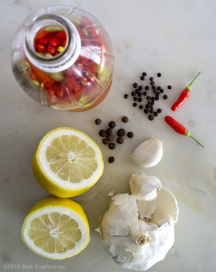 base ingredients for sautéed collard greens, tabasco vinegar, lemon juice, Jamaican pimento, garlic, black pepper and Tabasco peppers