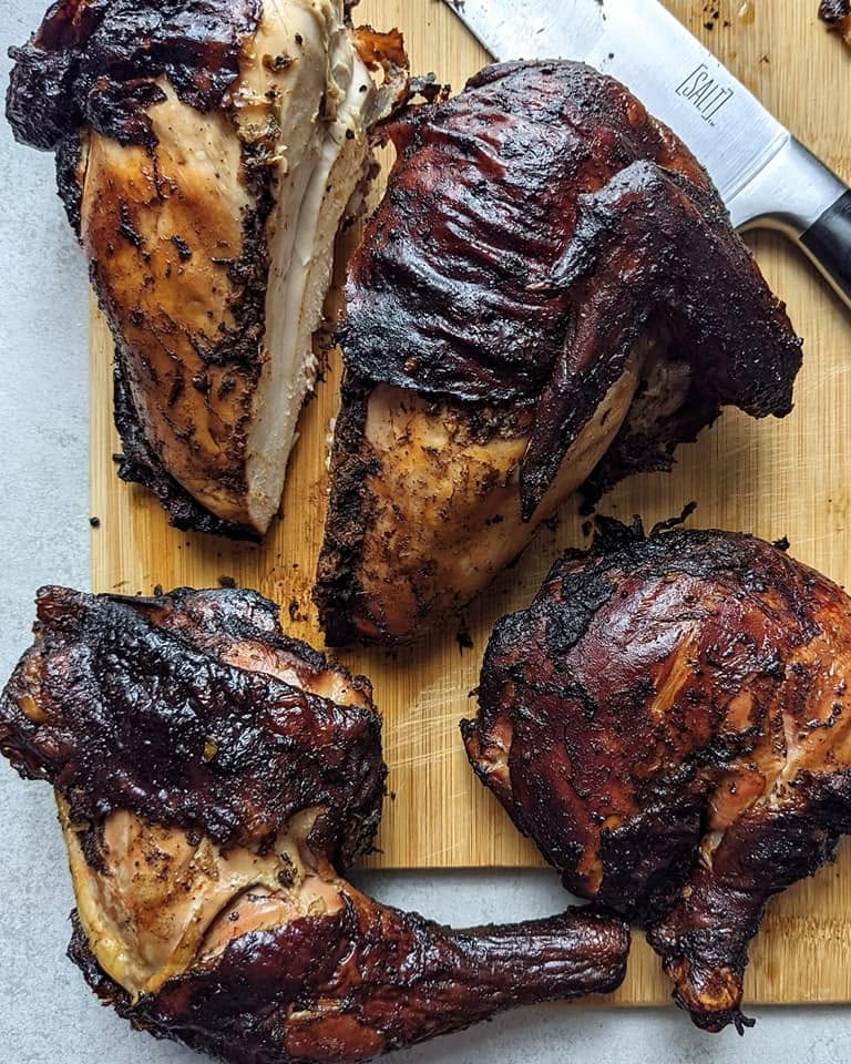 jerk chicken breasts and thighs cooked to completion on a cutting board